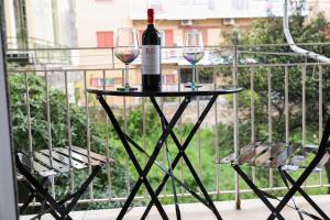 a table with two glasses of wine on a balcony at Irene house tenis club in Agios Rokkos