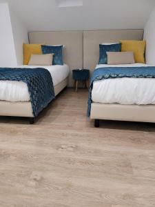 two beds in a room with wooden floors at Alojamento Local Vitoria in Batalha