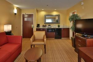 a living room with a red couch and a tv at Courtyard by Marriott Junction City in Junction City