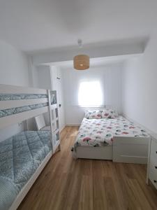 1 dormitorio con 2 literas y suelo de madera en Apartamento vacacional Roda de Barà, en Roda de Bará