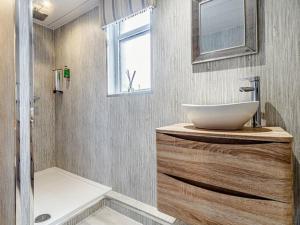 ein Badezimmer mit einem Waschbecken, einer Badewanne und einem Spiegel in der Unterkunft Golden Crown exclusive use spa venue in Tarbolton