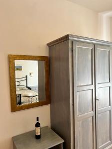 Hotel Marvin في مونتيبولسيانو: زجاجة من النبيذ موضوعة على طاولة بجوار مرآة