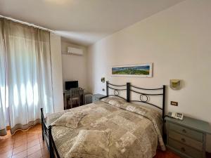 um quarto com uma cama e uma janela em Hotel Marvin em Montepulciano