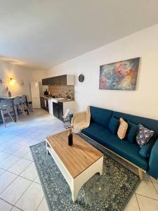 un soggiorno con divano blu e tavolo di "La maison Fabrin" Appart N2 Arles centre a Arles