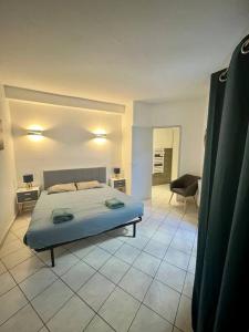 1 dormitorio con 1 cama y 1 silla en una habitación en "La maison Fabrin" Appart N2 Arles centre, en Arles
