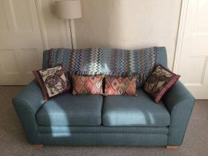 a blue couch with pillows on it in a room at Beautiful Apartment in Character Former Rectory in Penrith