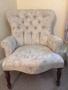 a white chair with flowers on it in a room at Beautiful Apartment in Character Former Rectory in Penrith