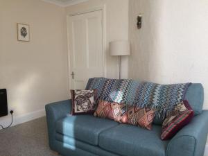 a blue couch with pillows in a living room at Beautiful Apartment in Character Former Rectory in Penrith