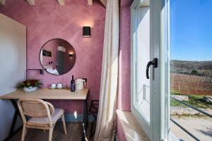 a room with a table and a mirror and a window at Winery Cuj Bed & Breakfast in Vilanija