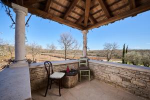 a patio with two chairs and a stone wall at Winery Cuj Bed & Breakfast in Vilanija