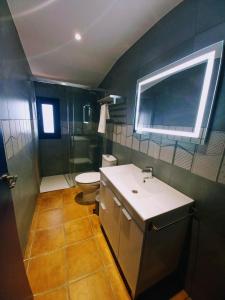 a bathroom with a sink and a toilet and a mirror at Masia St Salvador 1582 in Cubelles