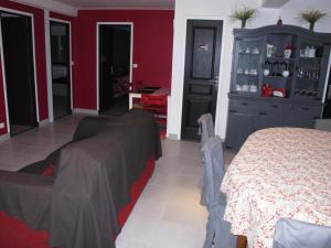sala de estar con cama y pared roja en La Vigneraie de Meusnes, en Meusnes