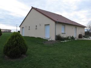 una casa blanca con techo rojo en un campo verde en La Vigneraie de Meusnes, en Meusnes