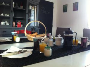 a kitchen counter with a basket of bread and orange juice at La Vigneraie de Meusnes in Meusnes