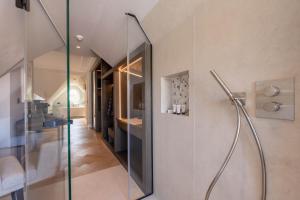 un bagno con doccia con porta in vetro di Clounys Hotel ad Amburgo