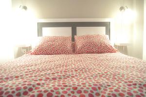 a bedroom with a large bed with red pillows at Apartamentos Catedral Plaza 3000 in Granada