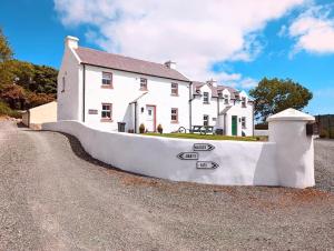 a large white house with a fence in front of it at Millers Close Holiday Cottages in Newcastle