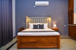 Tectona Grandis By Travel Corners في غامباها: غرفة نوم بسرير كبير مع اطار خشبي