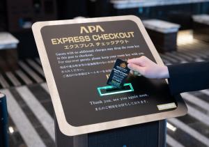 znak ekspresowego wymeldowania z ręką na nim w obiekcie APA Hotel Shinagawa Sengakuji Eki-Mae w Tokio