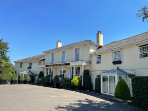 a large white house with a driveway in front of it at Alton House Hotel in Alton