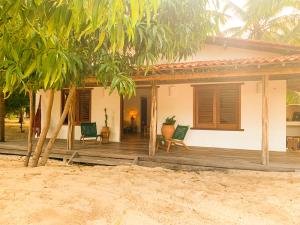Casa do CAMPO Atins com super Conforto في أتينز: منزل على الشاطئ مع شرفة خشبية