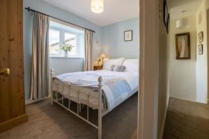 a bedroom with a bed and a window at Burn Cottage in Leyburn