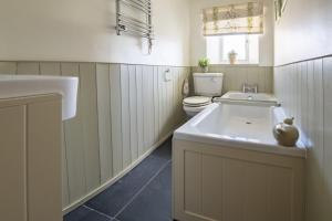 a bathroom with a sink and a toilet at Burn Cottage in Leyburn +24 photos
