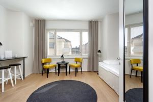 a living room with a table and yellow chairs at Forenom Serviced Apartments Helsinki Kruununhaka in Helsinki