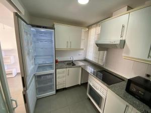 una piccola cucina con armadietti bianchi e frigorifero di Apartamentos Novacala Benidorm II a Benidorm