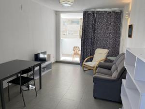 un soggiorno con divano, tavolo e sedie di Apartamentos Novacala Benidorm II a Benidorm