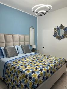 Exclusive apartment Piccola Marina في ايسكيا: غرفة نوم بسرير كبير مع بطانيه صفراء وزرقاء