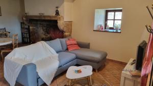 sala de estar con sofá azul y mesa en L'Oustalou - Maison-Jardin-Wifi en Villeneuve