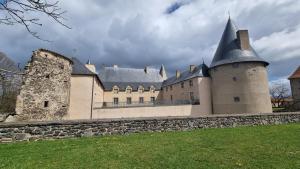 duży zamek z kamienną ścianą przed nim w obiekcie L'Oustalou - Maison-Jardin-Wifi w mieście Villeneuve