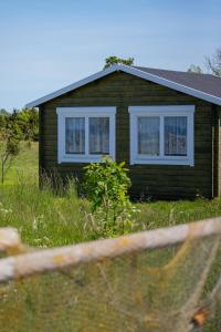 a small house with two windows in a field at Ohessaare mereäärne Camping in Ohessaare