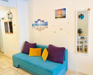 een blauwe bank met kleurrijke kussens in de woonkamer bij Royal Studio Sea View by Kaliakria in Topola