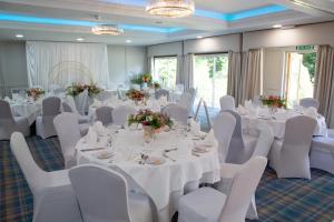 a banquet room with white tables and white chairs at Alton House Hotel in Alton