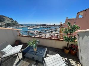 a balcony with chairs and a view of a marina at Cassis Loc - Chambre Meublée in Cassis