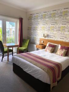 um quarto de hotel com uma cama, uma mesa e uma janela em Alton House Hotel em Alton