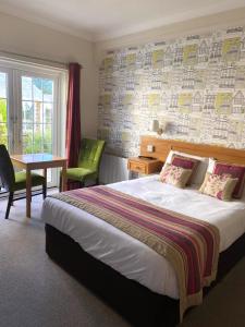a hotel room with a bed and a table and a window at Alton House Hotel in Alton