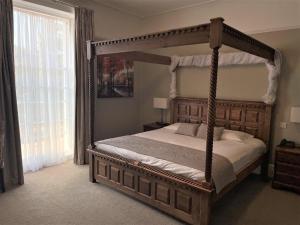 a bedroom with a canopy bed and a window at Alton House Hotel in Alton