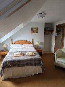 a bedroom with a bed with two towels on it at Doune Braes Hotel in Breasclete