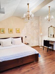 a bedroom with a bed and a desk and a chandelier at Zrinka House in Grabovac