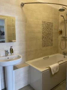 a bathroom with a sink and a bath tub next to a sink at Alton House Hotel in Alton