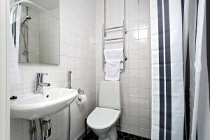 a white bathroom with a toilet and a sink at Forenom Serviced Apartments Helsinki Kruununhaka in Helsinki +37 photos