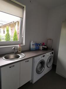 a kitchen with a washing machine and a sink at Kalinowy Sen II in Warsaw