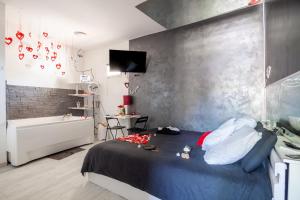 a bedroom with a bed and a bathroom with a tub at Love Room avec Balnéo in Toulon
