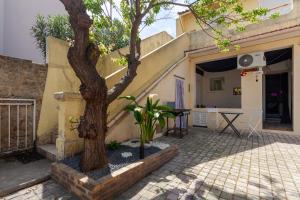 a tree in a courtyard next to a building at Love Room avec Balnéo in Toulon
