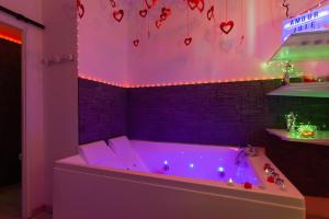 a purple bathroom with a tub with hearts on the wall at Love Room avec Balnéo in Toulon +18 photos