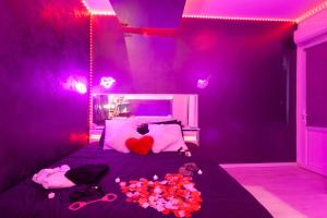 a purple bedroom with a bed with flowers on it at Love Room avec Balnéo in Toulon