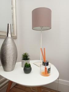 a white table with a lamp and plants on it at Nancy Ville in Nancy